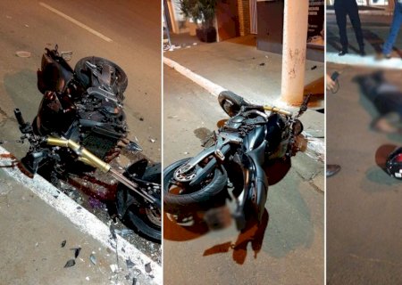 Moto fica destruída após condutor bater em poste de iluminação pública.